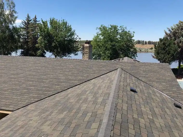 New shingle hip roof with the Columbia River visible past the eave