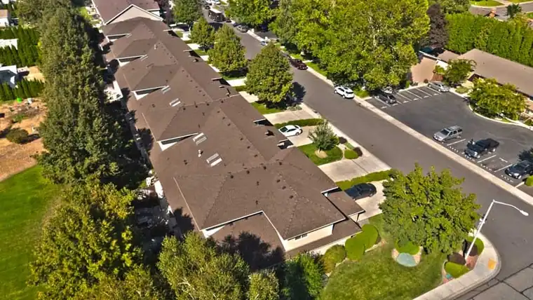 Drone view down a row of townhomes with matching new roofs