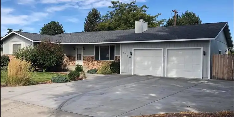 Ranch home with a two-car garage under a new shingle roof