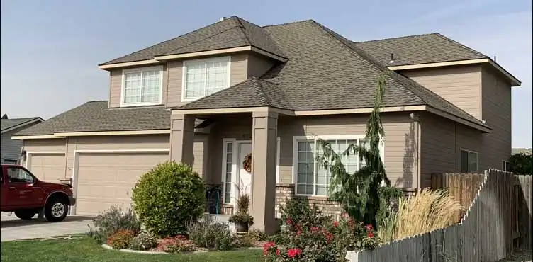 Two-storey home with a two-car garage and a landscaped front under a new shingle roof